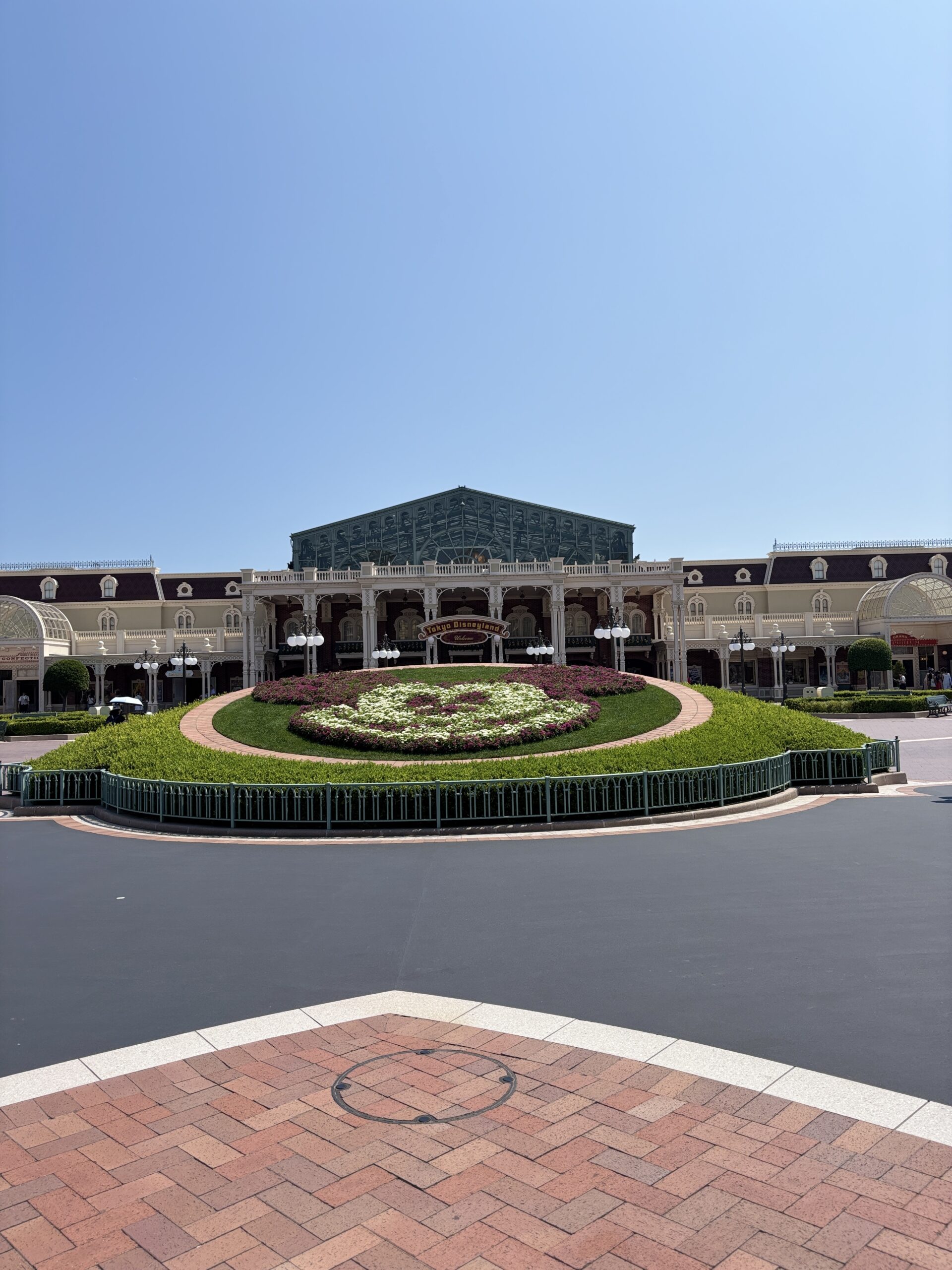 ミッキーの花壇の奥に見えるワールドバザール（アーケード）